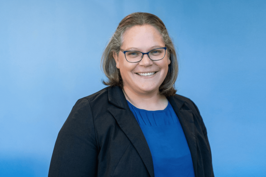 Rachael Orose headshot with a blue background