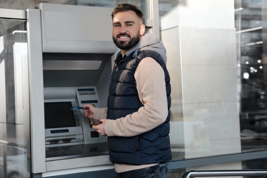Man smiling at a bank ATM