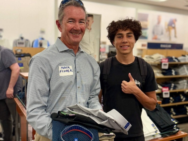 IMG_3240 2 2 Male volunteer and male teen holding dress shirts while shopping for professional clothing