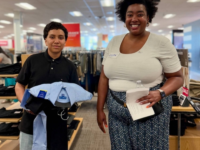 IMG_3242 2 2 female volunteer and male teen student holding clothes on hangars while shopping for professional clothing