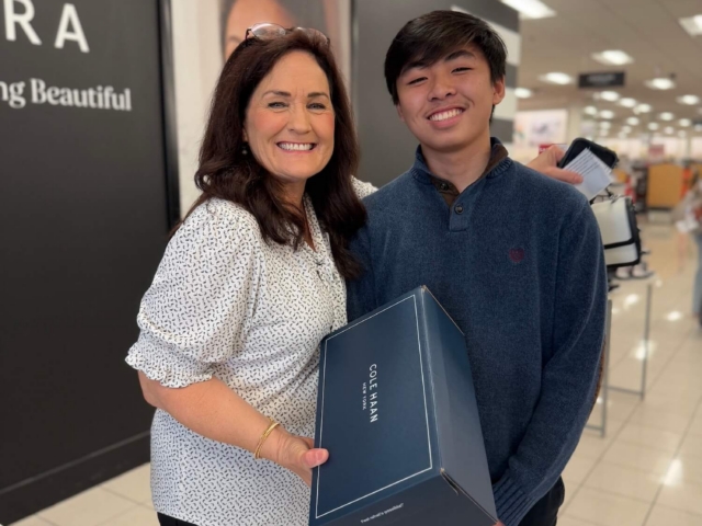 IMG_3250 2 Female volunteer and male teen holding a box of new shoes during a shopping event for Dream with STEAM