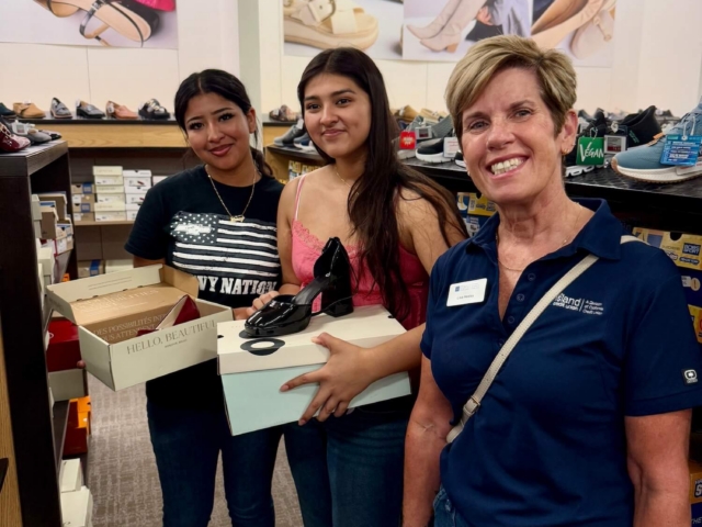 IMG_3278 Female volunteer and two female teens holding boxes of shoes during a shopping event