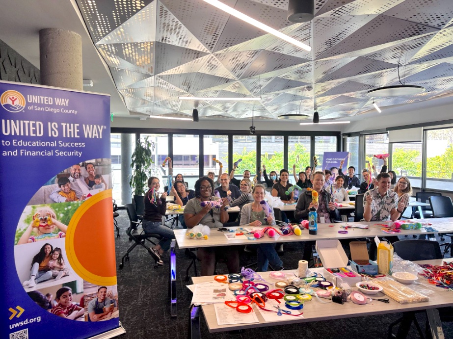 Employees making crafts and smiling during a Corporate Social Responsibility volunteer event through United Way of San Diego County